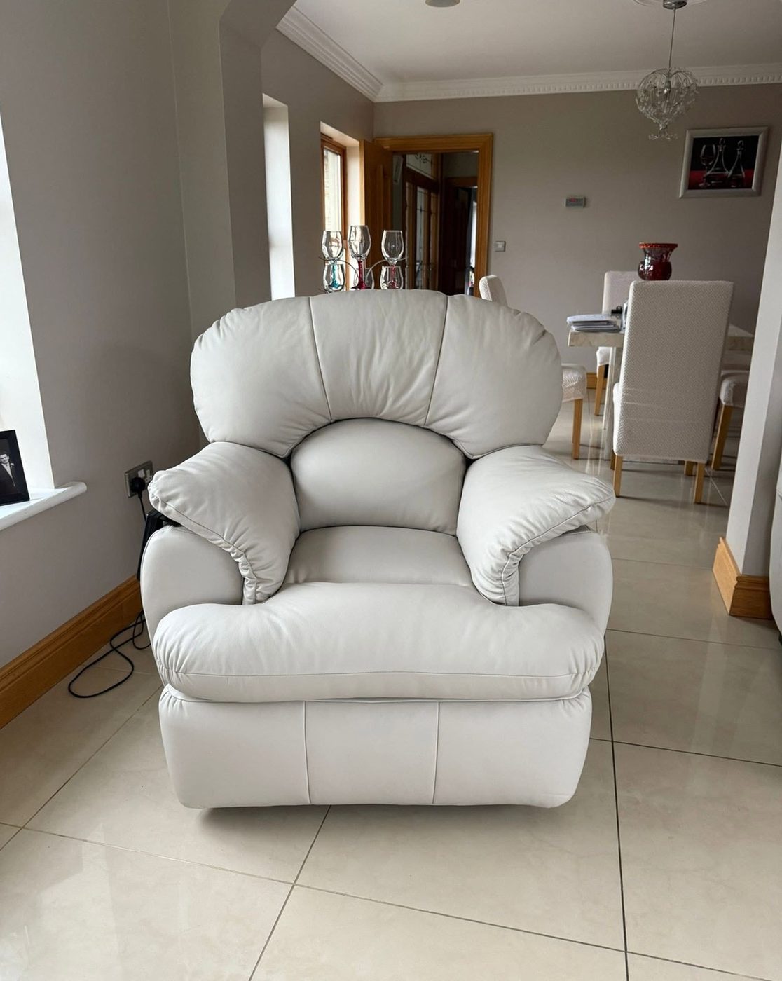 The same recliner finished in white, in a tiled room