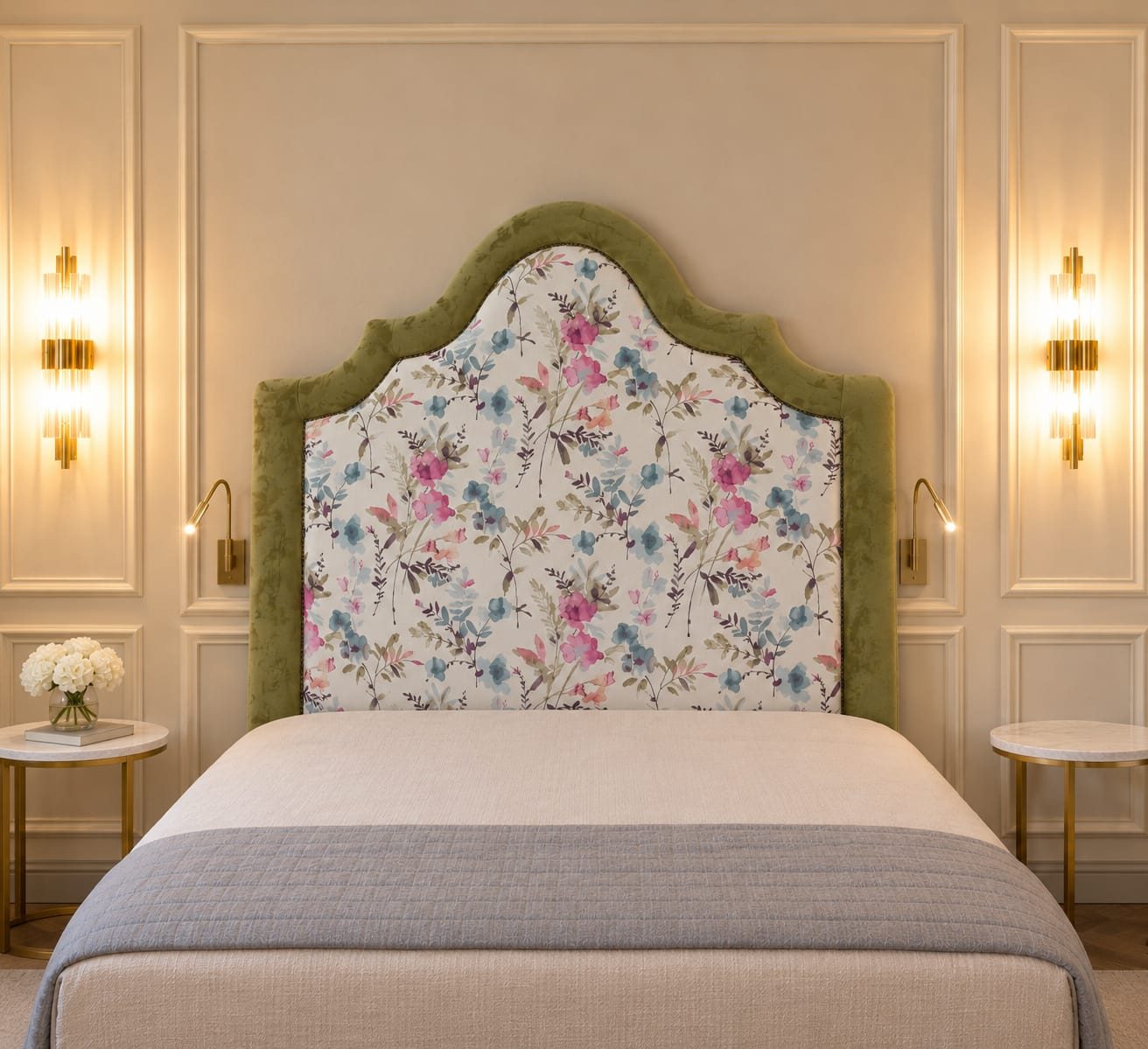 The floral headboard behind a bed between two wall sconces