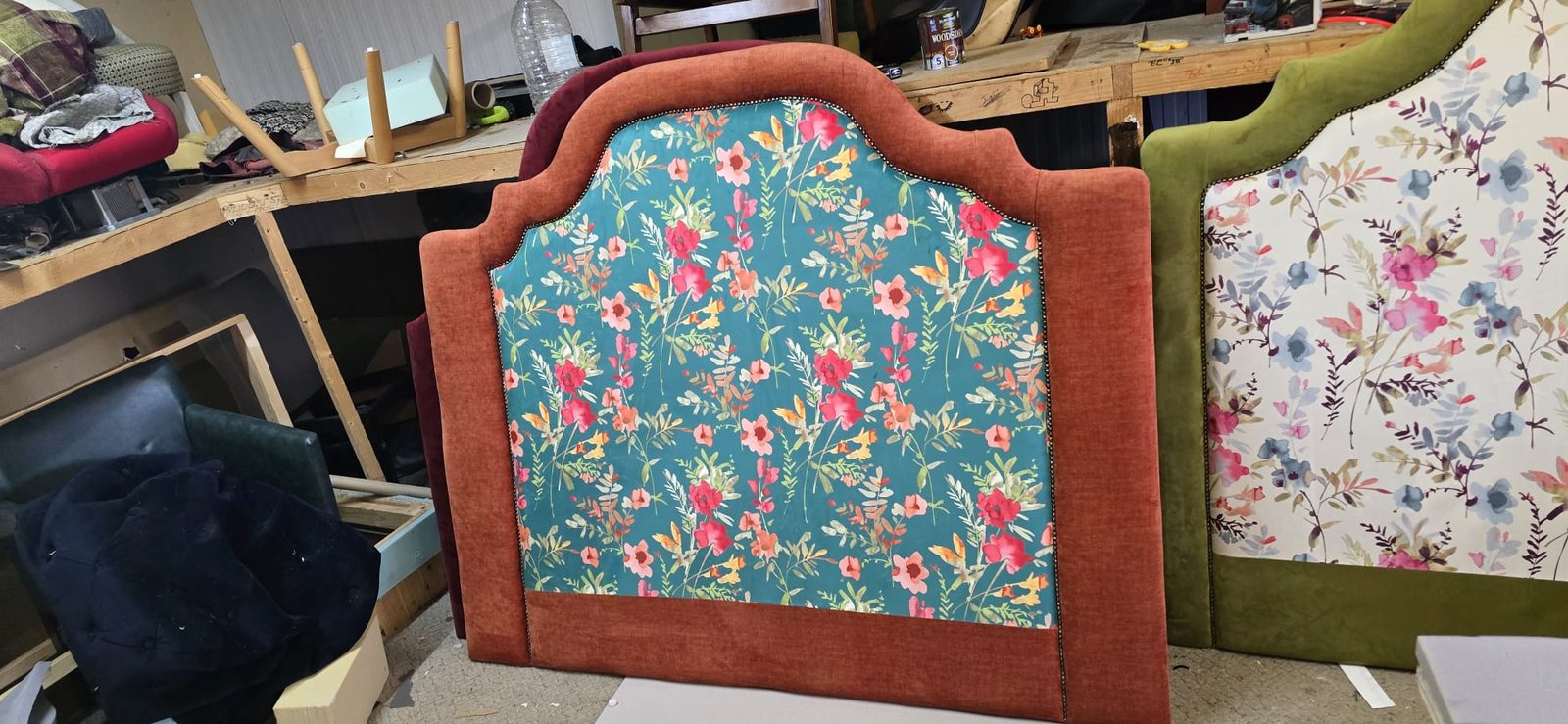 Close-up of a teal floral headboard with rust trim